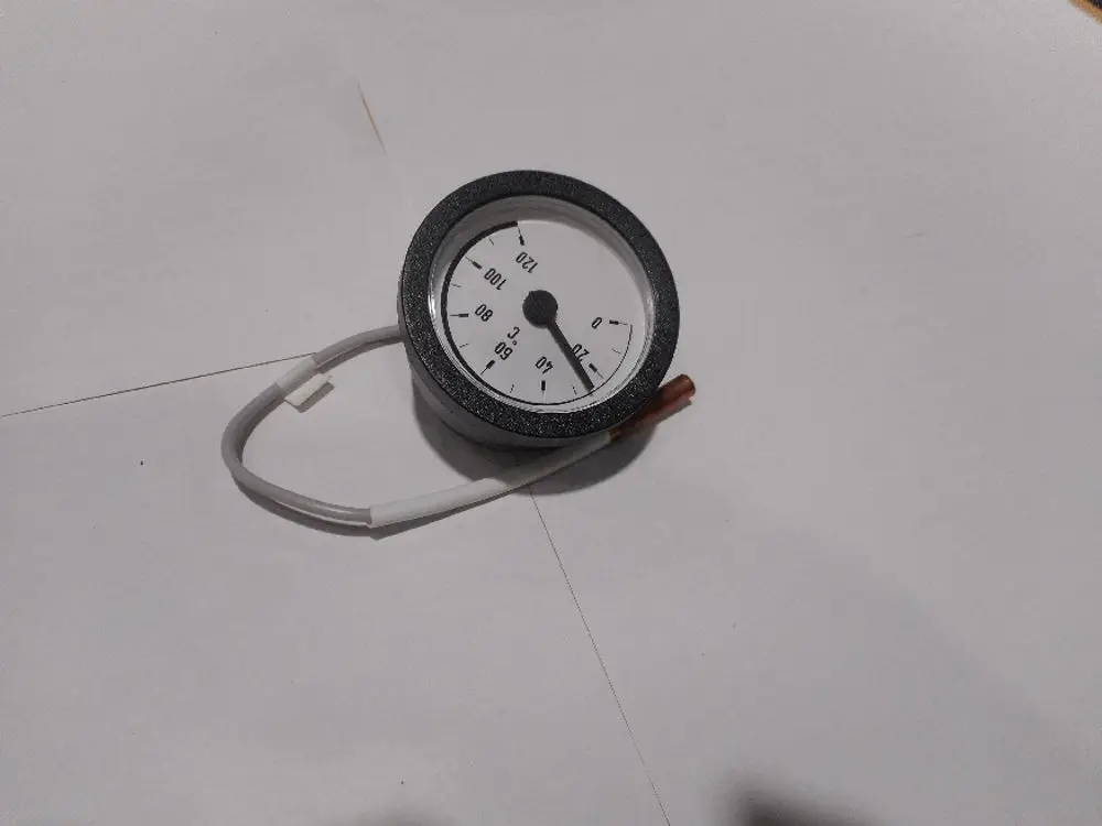 Remeha-Manometer mit analoger Anzeige, zeigt den Druck auf einer Skala bis 120 an, mit einem Verbindungsschlauch. Positioned auf einem weißen Untergrund.